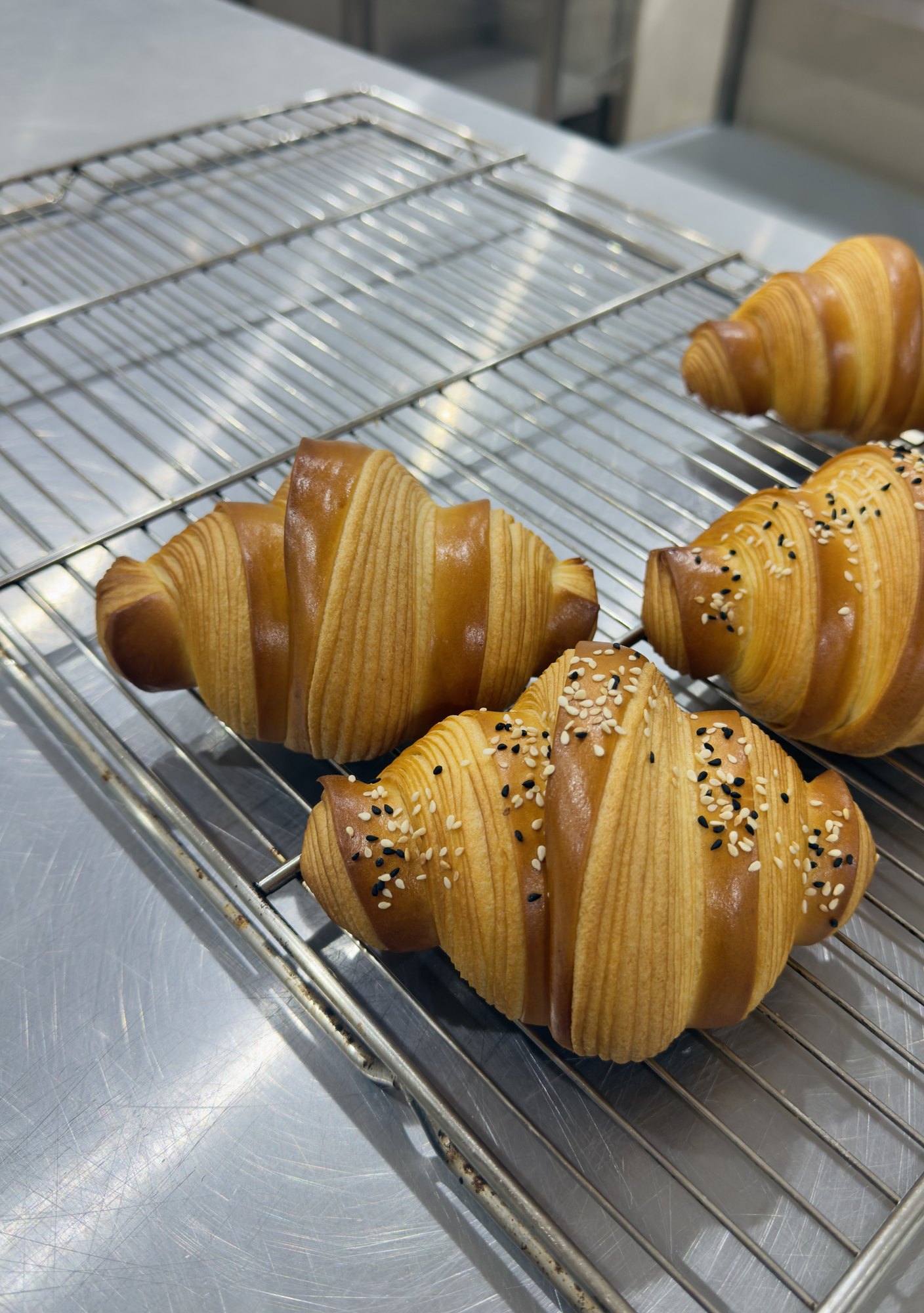 Baked seeded croissants on a cooling rack